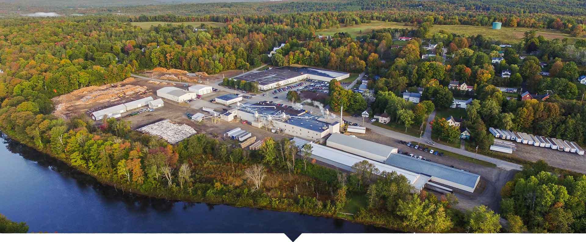 Aerial view of the Puritan buildings surrounded by trees and river